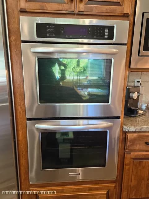 Professional installation of a stainless steel double oven into existing wooden kitchen cabinetry in the Elk Grove area.
