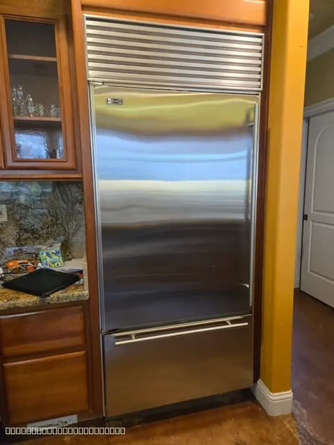 High-end Sub-Zero refrigerator installed perfectly within custom wood cabinetry in an Elk Grove home.